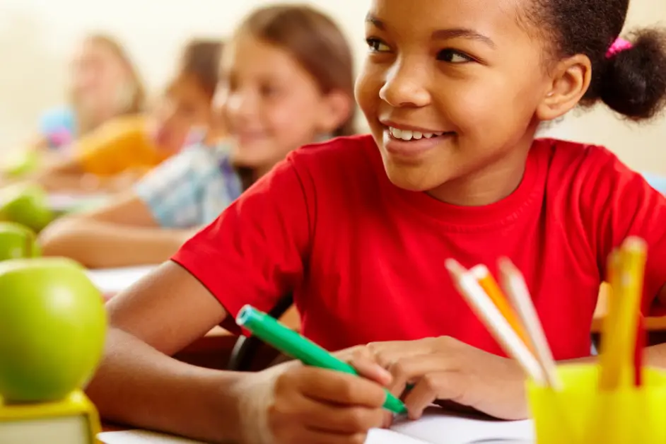 Row of pupils looking at teacher. How old are you in 5th grade?