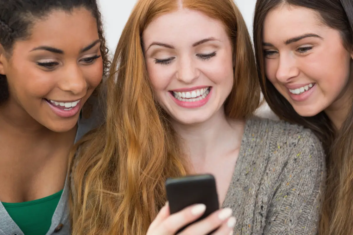 Picture of 3 moms looking at phone and laughing. Mom Fails.