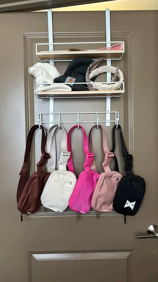 Picturesof how to organize belt bags. Hang belt bags on hooks over closet door. Belt bag organization