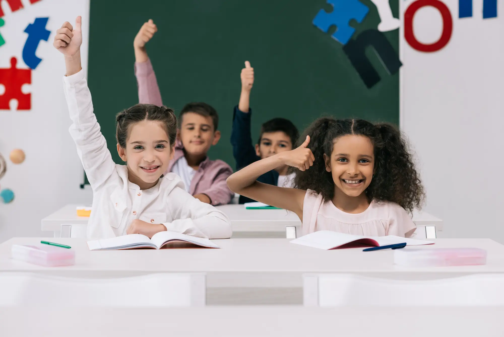 School children at desks raising their hands - How Old Are You In 3rd Grade